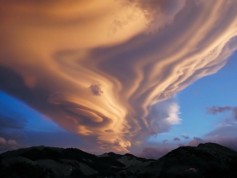 Dramatic lenticular clouds over mountains