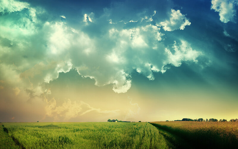 Dramatic sky over green fields