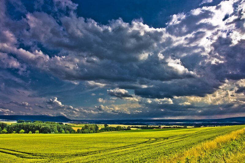 Dramatic sky over green fields