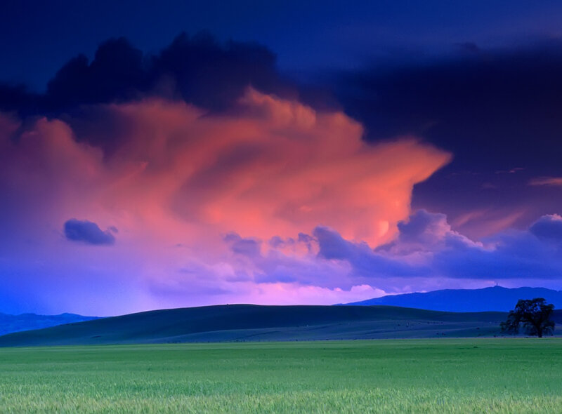 Dramatic storm over green fields