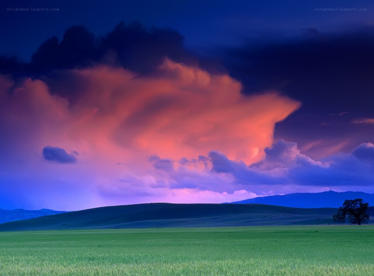 Dramatic storm over green fields