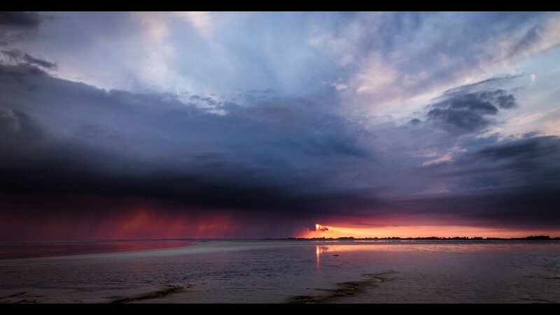 Dramatic stormy sunset over water