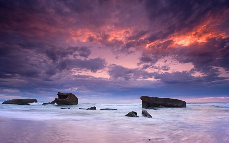 Dramatic sunset over coastal rocks