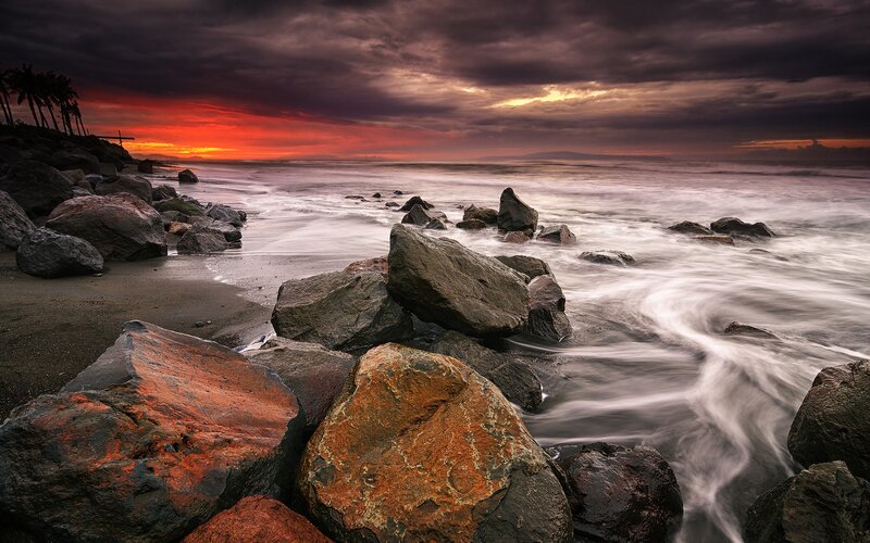 dramatic sunset over rocky beach