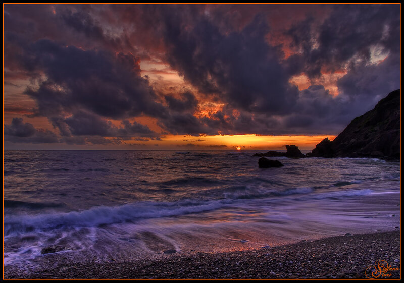 Dramatic sunset over rocky beach