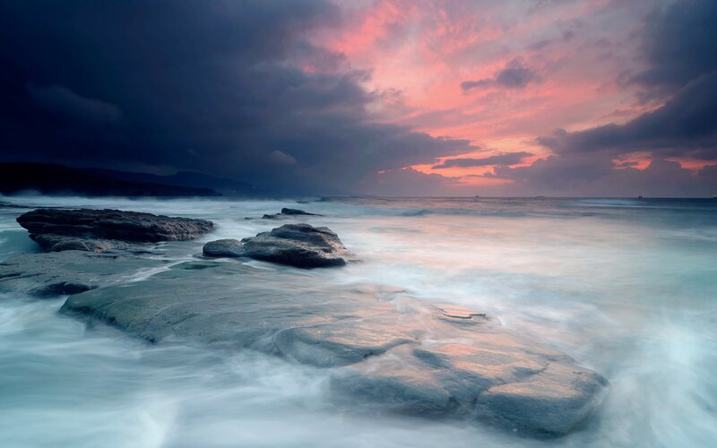 dramatic sunset over rocky shore