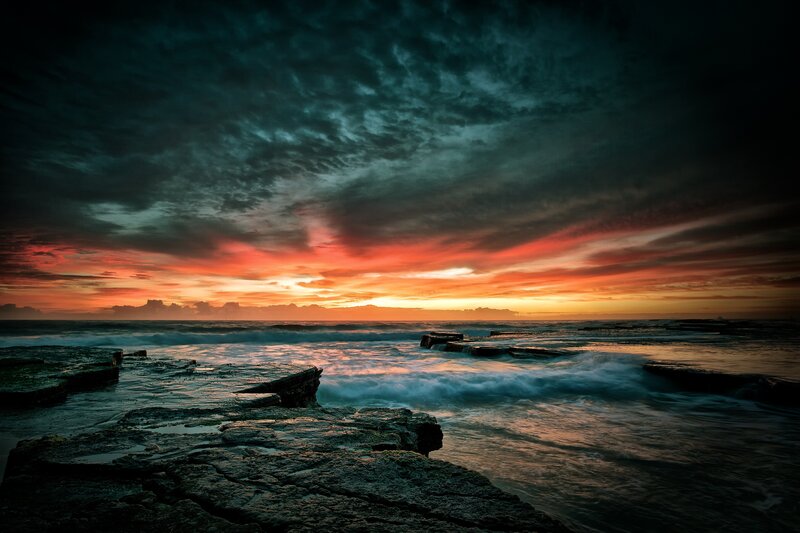 dramatic sunset over rocky shore