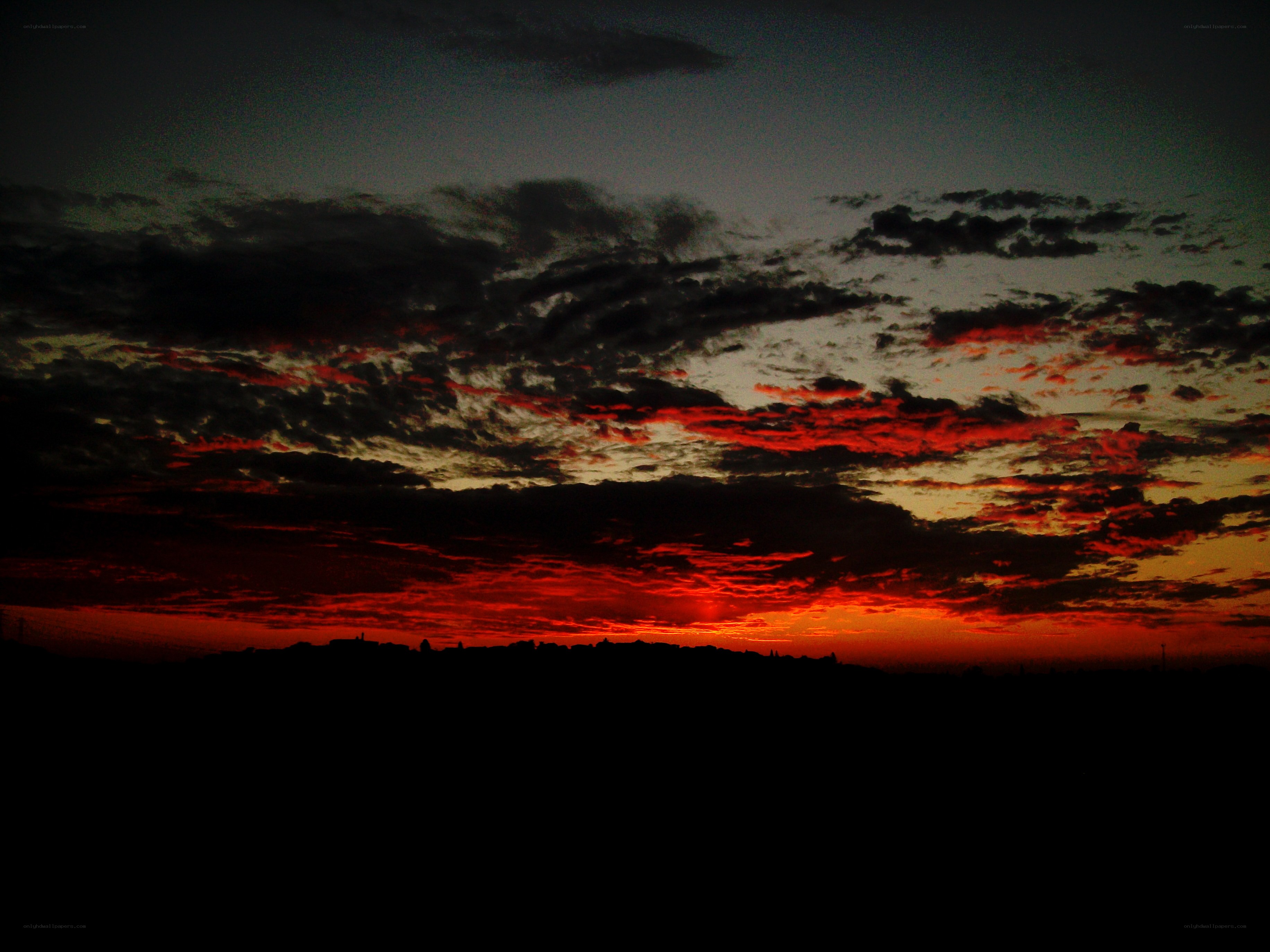 dramatic sunset over silhouetted landscape