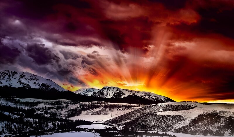 dramatic sunset over snow mountains