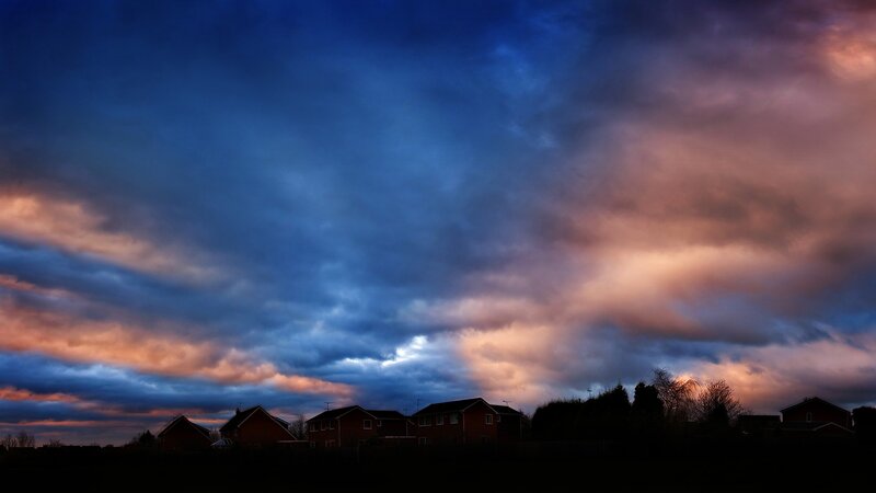 Dramatic sunset over suburban homes