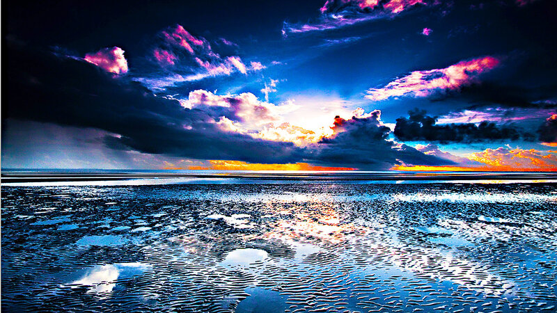 dramatic sunset over wet beach