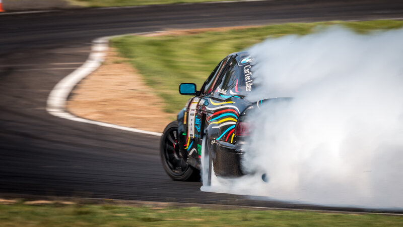 Drifting Race Car — Black, Dynamic, Afternoon, Photograph, Smoke, Racetrack, Grass