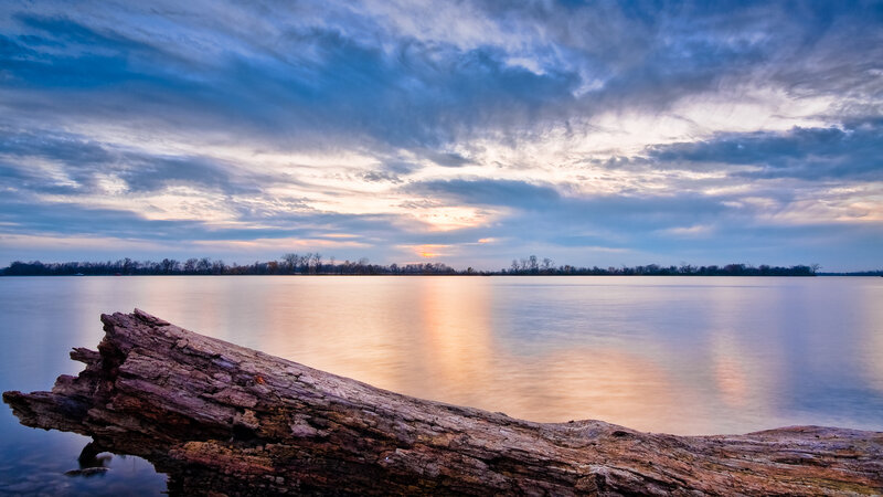 Driftwood at Sunset on a Calm Lake