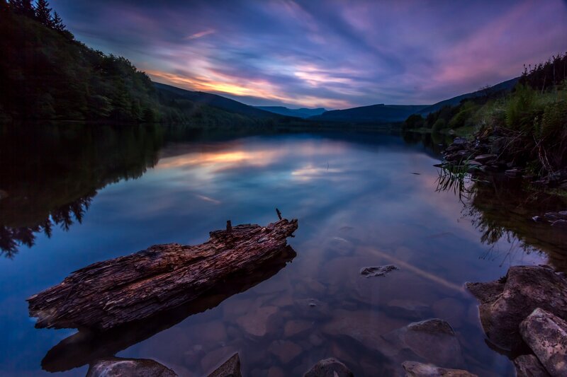 Driftwood in Lake — Blue, Serene, Sunset, Photograph, Mountains, Sky