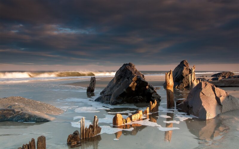 Driftwood on Beach — Gray, Dramatic, Sunset, Photograph, Rocks