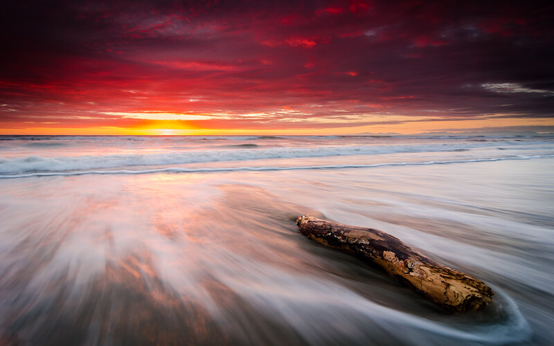 Driftwood on Beach — Red, Dramatic, Sunset, Photograph, Ocean