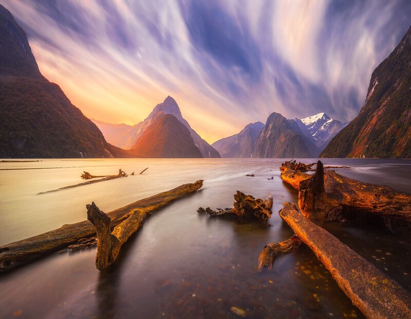 Driftwood on Lake Shore — Blue, Serene, Sunset, Photograph, Mountains, Sky, Clouds