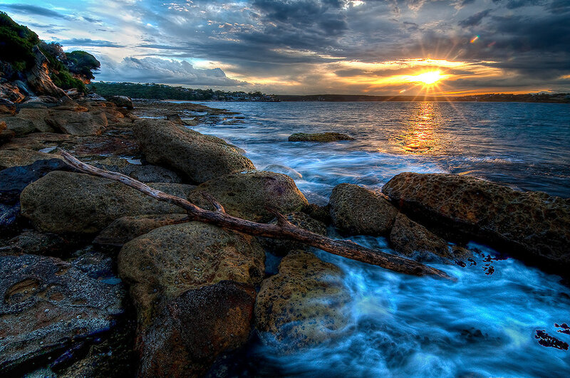 Driftwood on Rocky Shore — Blue, Dramatic, Sunset