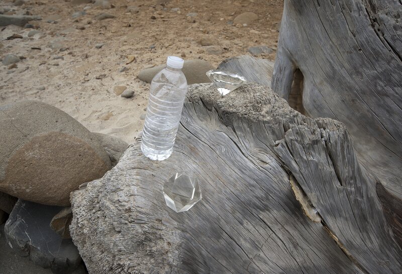 Driftwood with water bottle and crystals