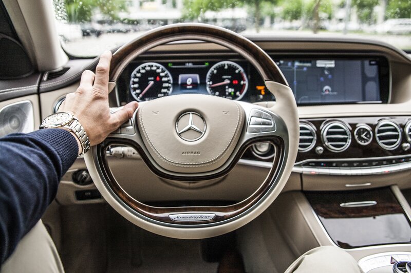 Driver's hand on Mercedes steering wheel