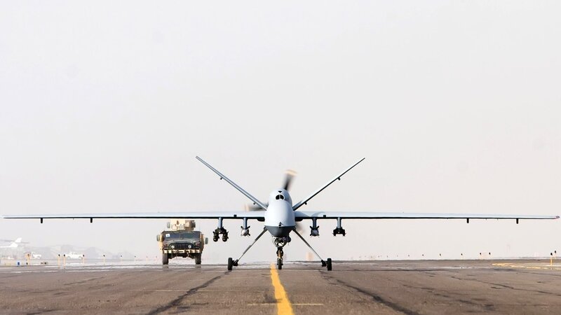 Drone on a runway with military vehicle