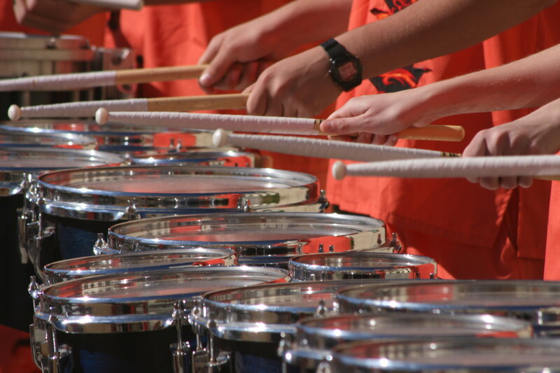Drummers performing in orange uniforms