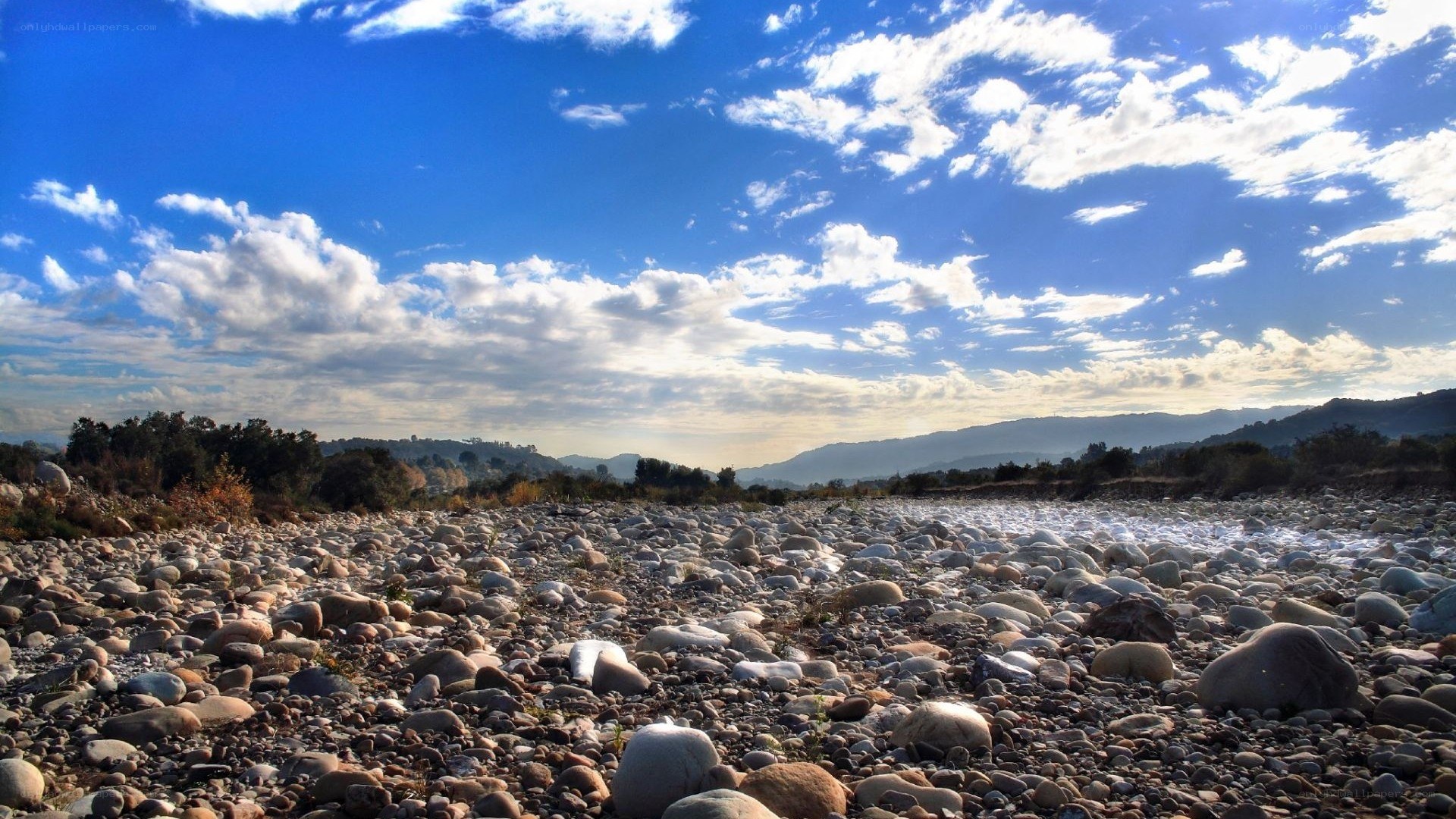 Dry riverbed under blue sky