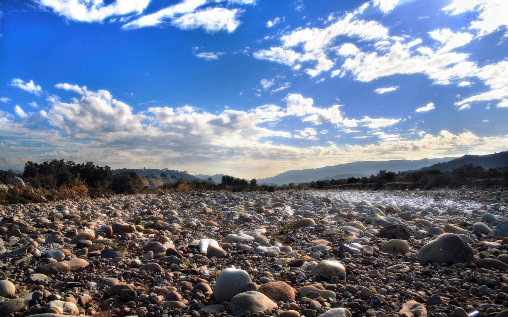 Dry riverbed under blue sky