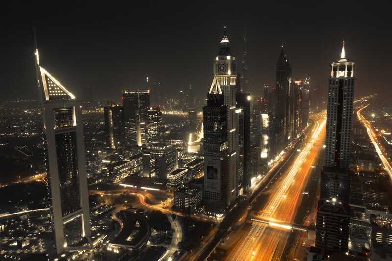 Dubai Skyline at Night — Black, Dramatic, Photograph, Skyscrapers, Highway, Light Trails