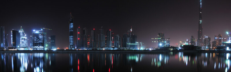 Dubai Skyline at Night — Black, Dramatic, Photograph, Skyscrapers, Water, Construction Cranes, Blue