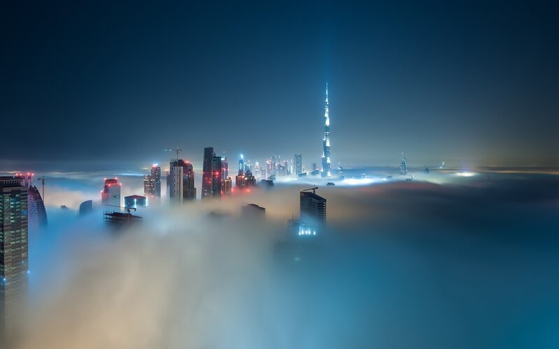Dubai Skyline at Night — Blue, Dramatic, Photograph, Skyscrapers, Clouds, Fog