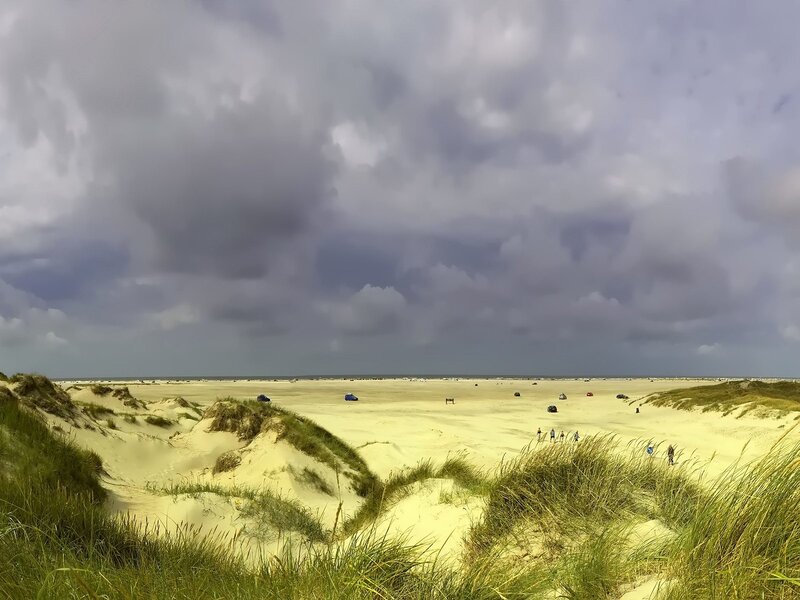 Dunes and beach under cloudy sky