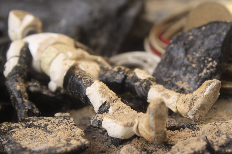 dusty action figure in debris