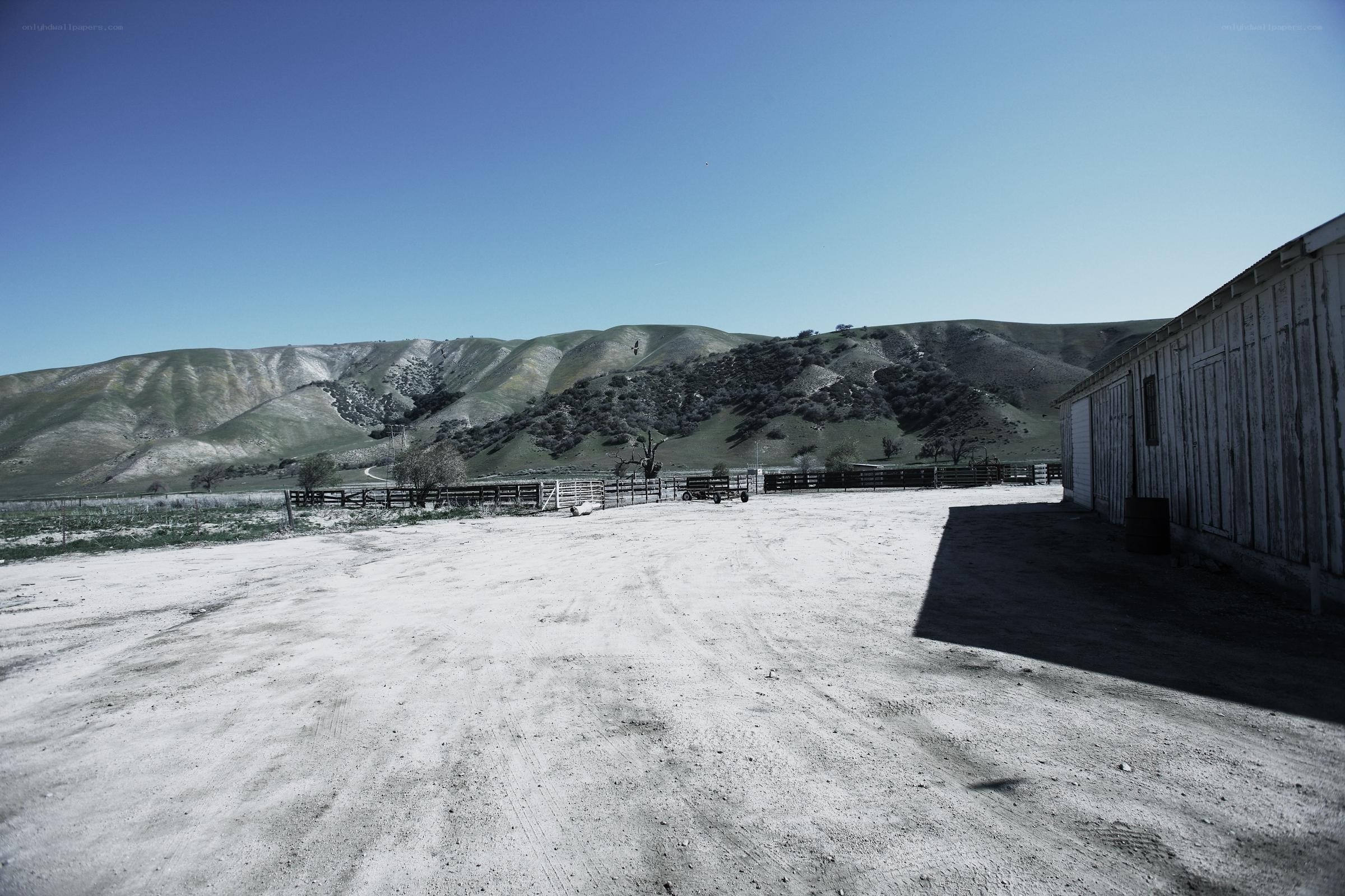 Dusty farmyard with hills