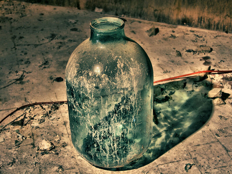 Dusty glass bottle on concrete