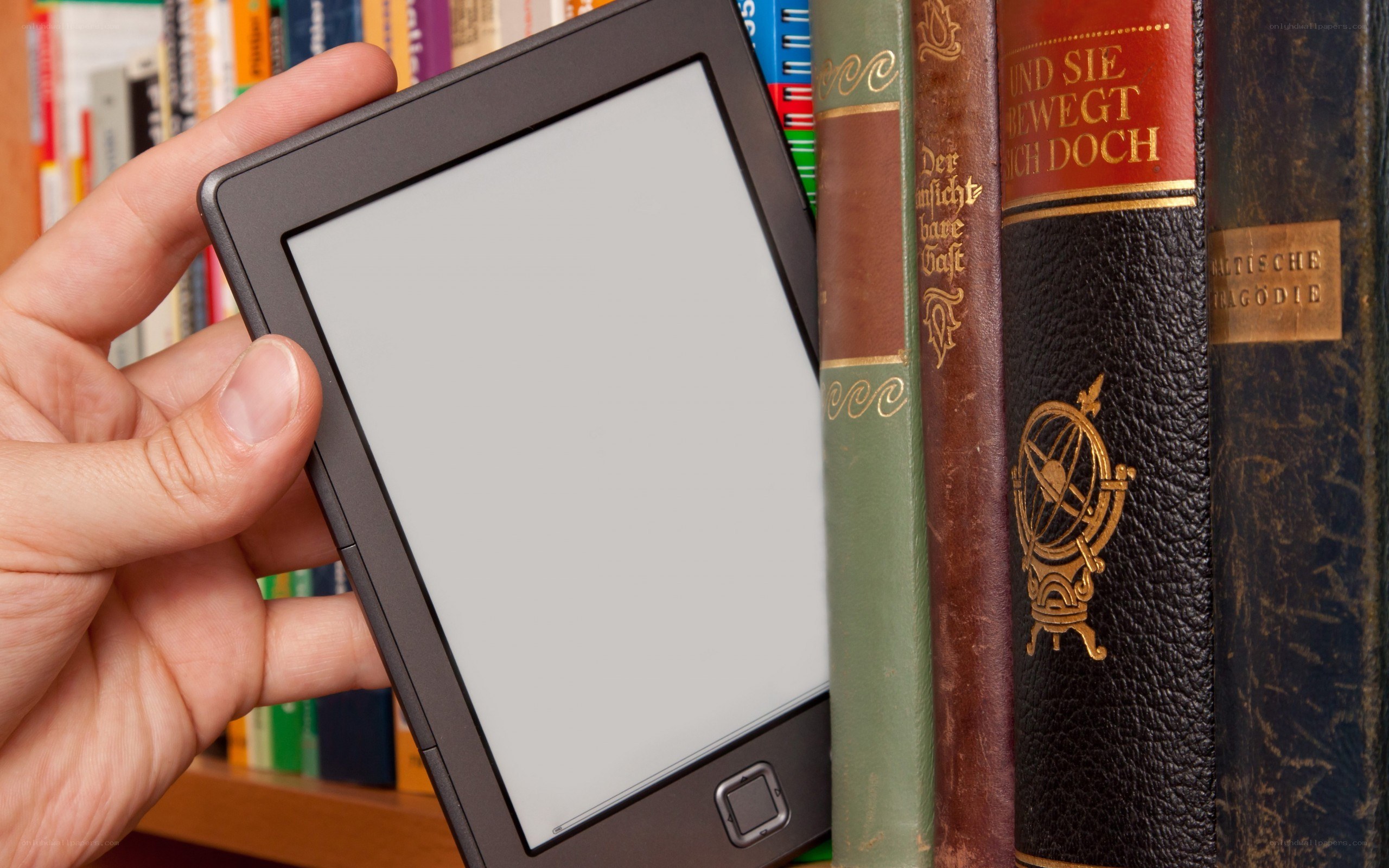 e-reader in hand near books