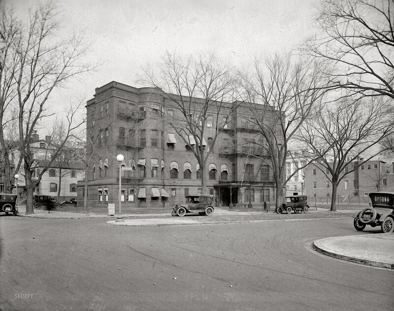 Early 1900s street scene with vintage cars