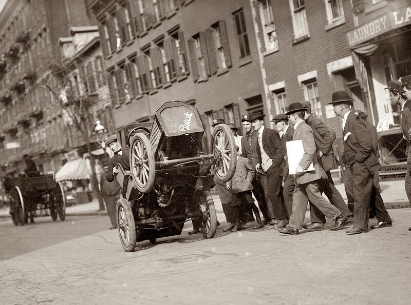 Early automobile on city street