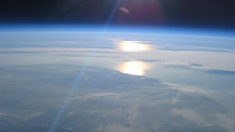 Earth from space with sun reflection