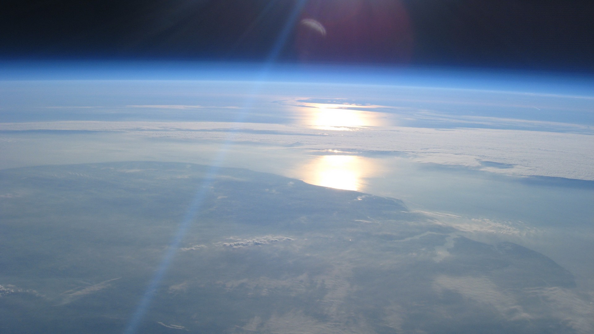 Earth from space with sun reflection