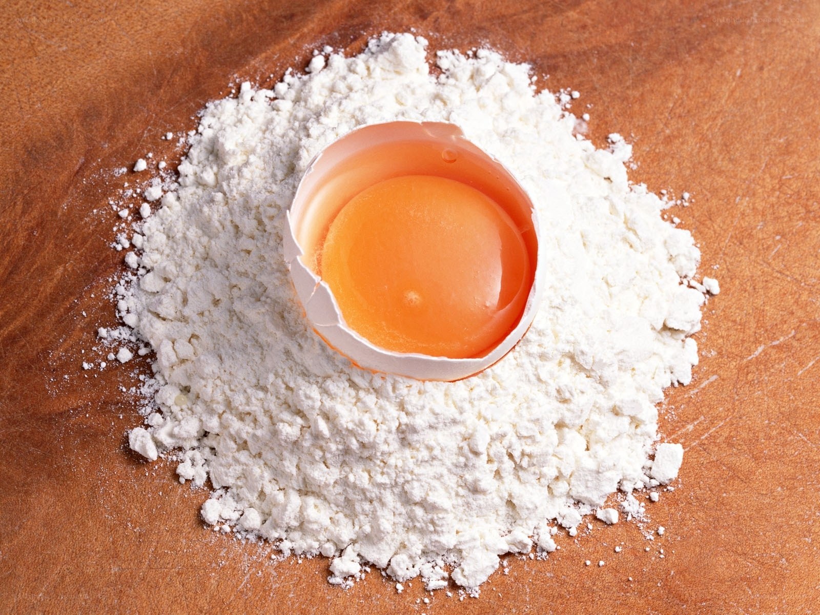 egg in flour on wooden surface