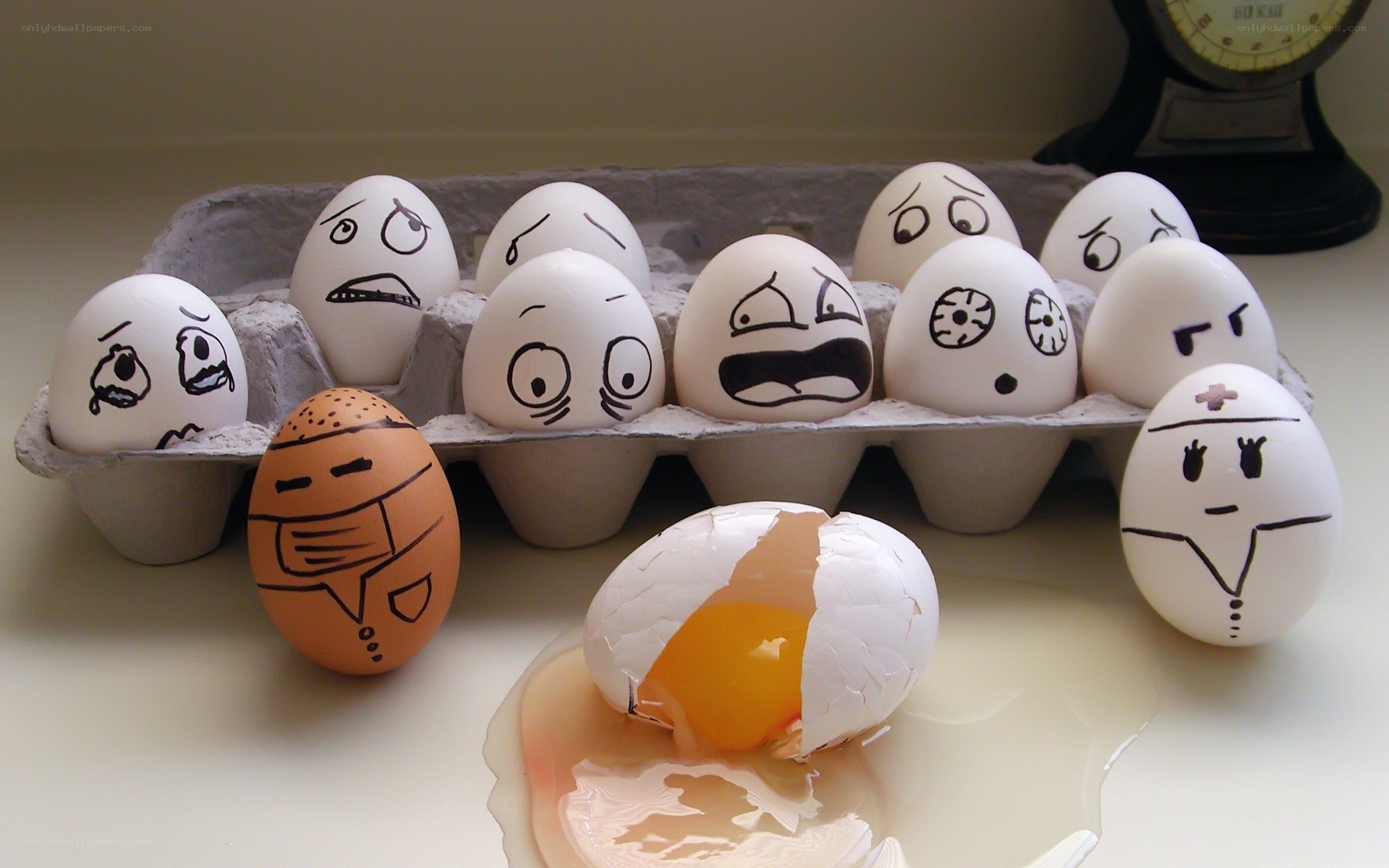 Eggs with drawn faces in a carton