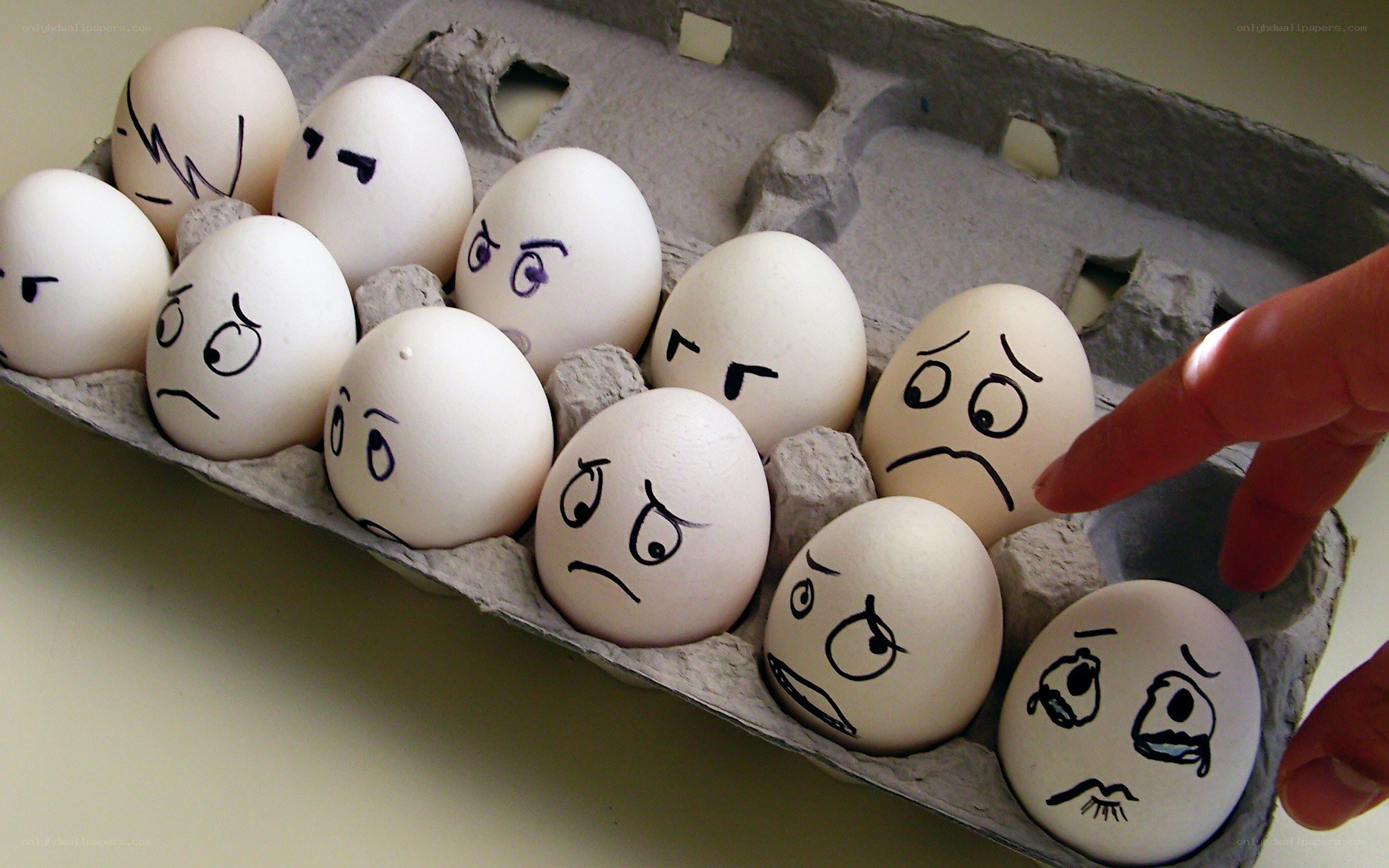 eggs with drawn faces in carton
