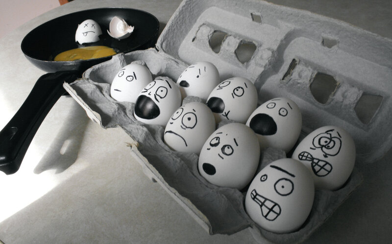 Eggs with drawn faces in carton