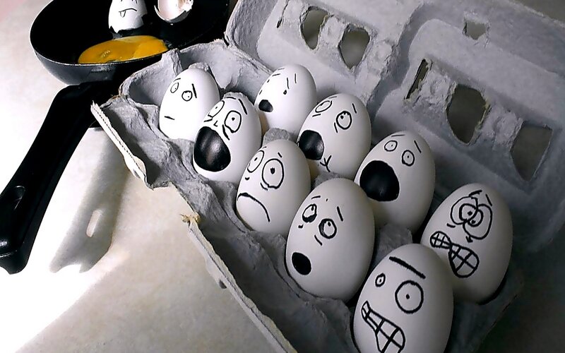 Eggs with drawn faces in carton
