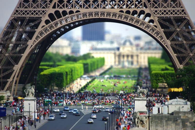 Eiffel Tower Arch View — Green, Bustling, Afternoon, Photograph, Crowd