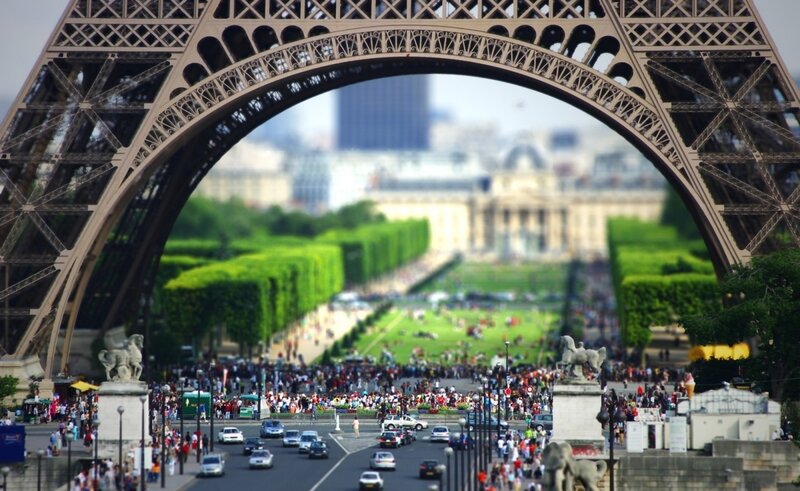 Eiffel Tower Arch View — Green, Bustling, Afternoon
