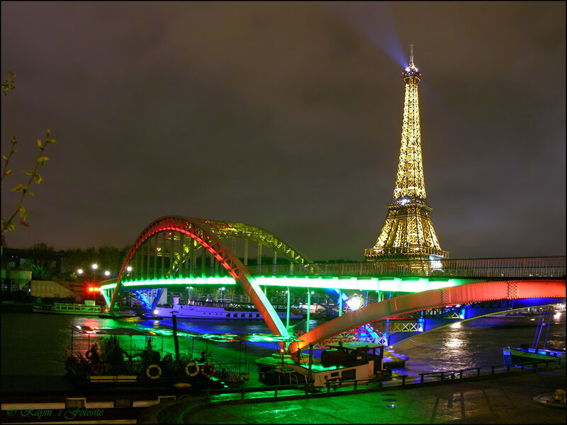 Eiffel Tower at night with colorful bridge