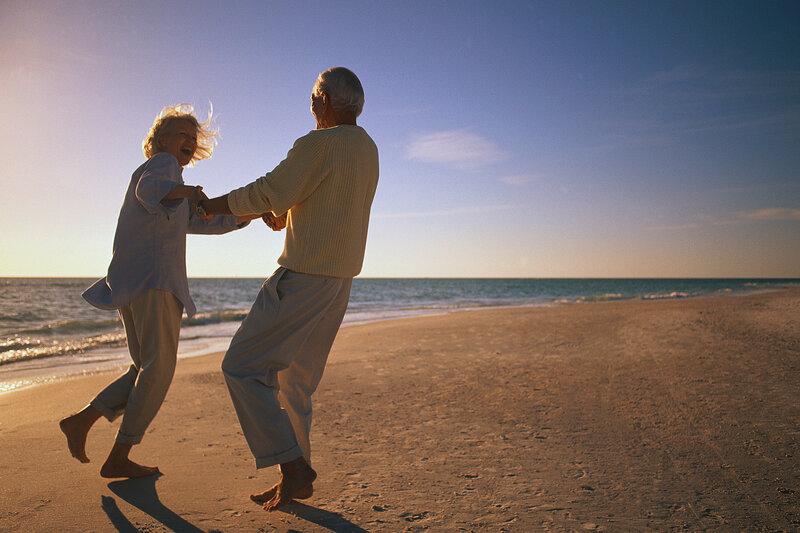 Elderly couple dancing on beach