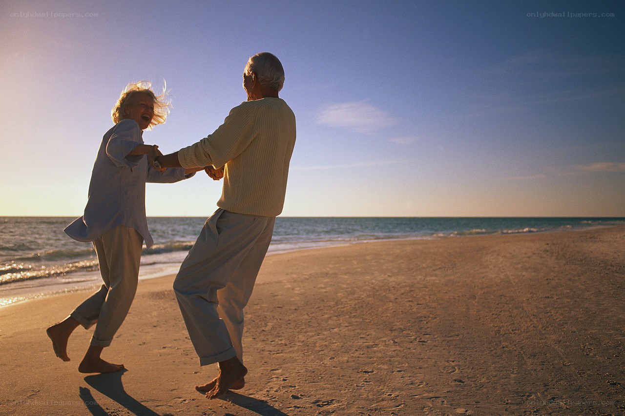 Elderly couple dancing on beach